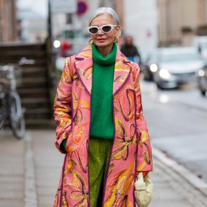 COPENHAGEN, DENMARK - FEBRUARY 02: Grece Ghanem is seen wearing pink coat with print, green turtleneck, green Stine Goya outside Stine Goya during Copenhagen Fashion Week Autumn/Winter 2022 on February 02, 2022 in Copenhagen, Denmark. (Photo by Christian Vierig/Getty Images)