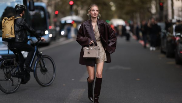 PARIS, FRANCE - SEPTEMBER 28: Leonie Hanne is seen wearing shiny silver earrings in a large organic shape from Alaïa; a burgundy leather coat with lapel collar from Hermès; a beige transparent set underneath, consisting of a shirt tucked into shorts; a gold ring; a beige suede “Birkin Grizzly“ bag from Hermès; and pointed shiny burgundy leather knee-high stiletto boots with a cylindrical shaft from Paris Texas before the Hermès Womenswear Spring/Summer 2025 Show as part of Paris Fashion Week on September 28, 2024 in Paris, France. (Photo by Jeremy Moeller/Getty Images)