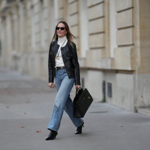 PARIS, FRANCE - NOVEMBER 05: Alba Garavito Torre wears long straight brown hair, a black leather jacket with gold buttons by Maison123, an ivory white turtleneck t-shirt by Maison123, light blue straight-leg jeans by Citizens of Humanity, black shiny leather pointed-toe high heel ankle boots by Jonak, a black leather bag by DeMellier London, and gold jewelry by Sempiterno Paris, during a street style fashion photo session, on November 05, 2025 in Paris, France. (Photo by Edward Berthelot/Getty Images)