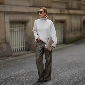 HAMBURG, GERMANY - SEPTEMBER 19: Alexandra Siedschlag is seen wearing a relaxed, high-collar ivory cashmere pullover with a soft ribbed texture from & Other Stories; khaki brown nappa sheepskin leather trousers with decorative stitching and wide leg silhouette from Bonprix; pointed dark brown suede boots with stiletto heel from Arket; a structured taupe leather Milo shoulder bag with gold hardware from Sézane; golden mid sized hoop earrings from Sence Copenhagen; oversized square sunglasses with acetate frame, golden logo detail on the temples and gradient glasses from Fendi; her blonde hair is styled in a sleek bob on September 19, 2025 in Hamburg, Germany. (Photo by Moritz Scholz/Getty Images)