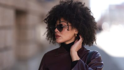 BERLIN, GERMANY - FEBRUARY 25: Julia Dalia seen wearing Tiffany & Co silver sunglasses, gold earrings, Arket black wool knit high neck sweater, burgundy red leather cropped jacket, on February 25, 2024 in Berlin, Germany. (Photo by Jeremy Moeller/Getty Images)