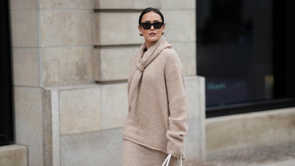 HAMBURG, GERMANY - OCTOBER 16: Laura Noltemeyer is seen wearing an oversized beige alpaca wool sweater with tie-back detailing by Aylin König; a long alpaca wool knit skirt in a straight cut by Aylin König; an alpaca knit scarf draped and knotted around the neck by Aylin König; a white intrecciato leather handbag called „Arco Bag“ by Bottega Veneta; slim black cat-eye sunglasses by Yves Saint Laurent; gold statement earrings with a green stone detail by Mango; her brown and straight hair is tied in a low ponytail on October 16, 2025 in Hamburg, Germany. (Photo by Moritz Scholz/Getty Images)
