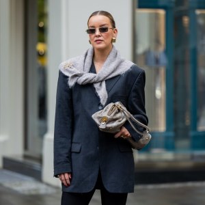 BERLIN, GERMANY - OCTOBER 08: Tina Haase wears vintage black oversize blazer, Black stirrup leggings, taupe knit triangle scarf Massimo Dutti, Loewe brooch, taupe grey Prada Bag on October 08, 2025 in Berlin, Germany. (Photo by Christian Vierig/Getty Images)