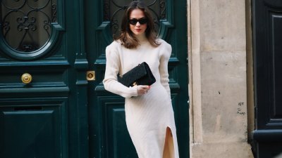 Therese Hellström wears sunglasses, a white wool turtleneck slit dress with shoulder pads, a Chanel bag, black pointy shoes, on November 19, 2020 in Paris, France.