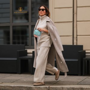 Elise Soho wearing Birkenstock beige sandals, Joseph beige two piece, Nanushka beige coat, Loewe mini blue baby bag on August 30, 2021 in Hamburg, Germany.