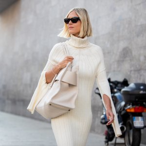 Linda Tol outside Max Mara fashion show wearing a knitted white dress, oversized white bag and sunglasses during the Milan Fashion Week - Spring / Summer 2022 on September 22, 2022 in Milan, Italy.