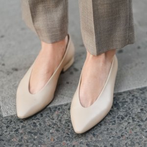 PARIS, FRANCE - MARCH 25: A close-up of beige pointed-toe leather pumps worn with taupe wool trousers, during a street style fashion photo session on March 25, 2025 in Paris, France. (Photo by Edward Berthelot/Getty Images)