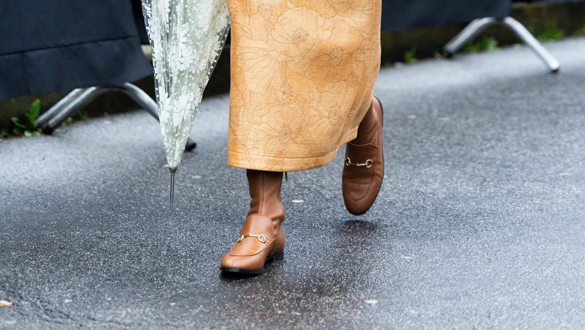 MILAN, ITALY - FEBRUARY 25: Jenny Walton wears beige leather Gucci boots, a green suede Gucci Horsebit bag, grey pendant earrings and a three-pieces brown leather and beige fabrics coord set made of a cropped top, a cropped jacket and a high waist midi skirt outside Gucci show during the Milan Fashion Week Womenswear Fall/Winter 2025/2026 on February 25, 2025 in Milan, Italy. (Photo by Valentina Frugiuele/Getty Images)
