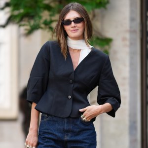 COPENHAGEN, DENMARK - AUGUST 05: A guest wears a black tailored jacket with a structured fit and three-quarter sleeves, paired with dark blue denim jeans. A white scarf is draped around the neck. Accessories include black rectangular sunglasses and a silver metallic oval-shaped handbag with a loop handle. Footwear consists of black slouchy leather boots with a pointed toe and high heel, outside Skall Studio, during Copenhagen Fashion Week, on August 05, 2025 in Copenhagen, Denmark (Photo by Edward Berthelot/Getty Images)