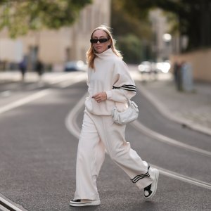 Sonia Lyson seen wearing Linda Farrow black sunglasses, Adidas white two-piece / white logo cotton oversized sweater and matching white wide leg pants, Miu Miu white leather Pocket bag, Copenhagen Studios white with black details leather sneakers, on September 03, 2023 in Berlin, Germany.
