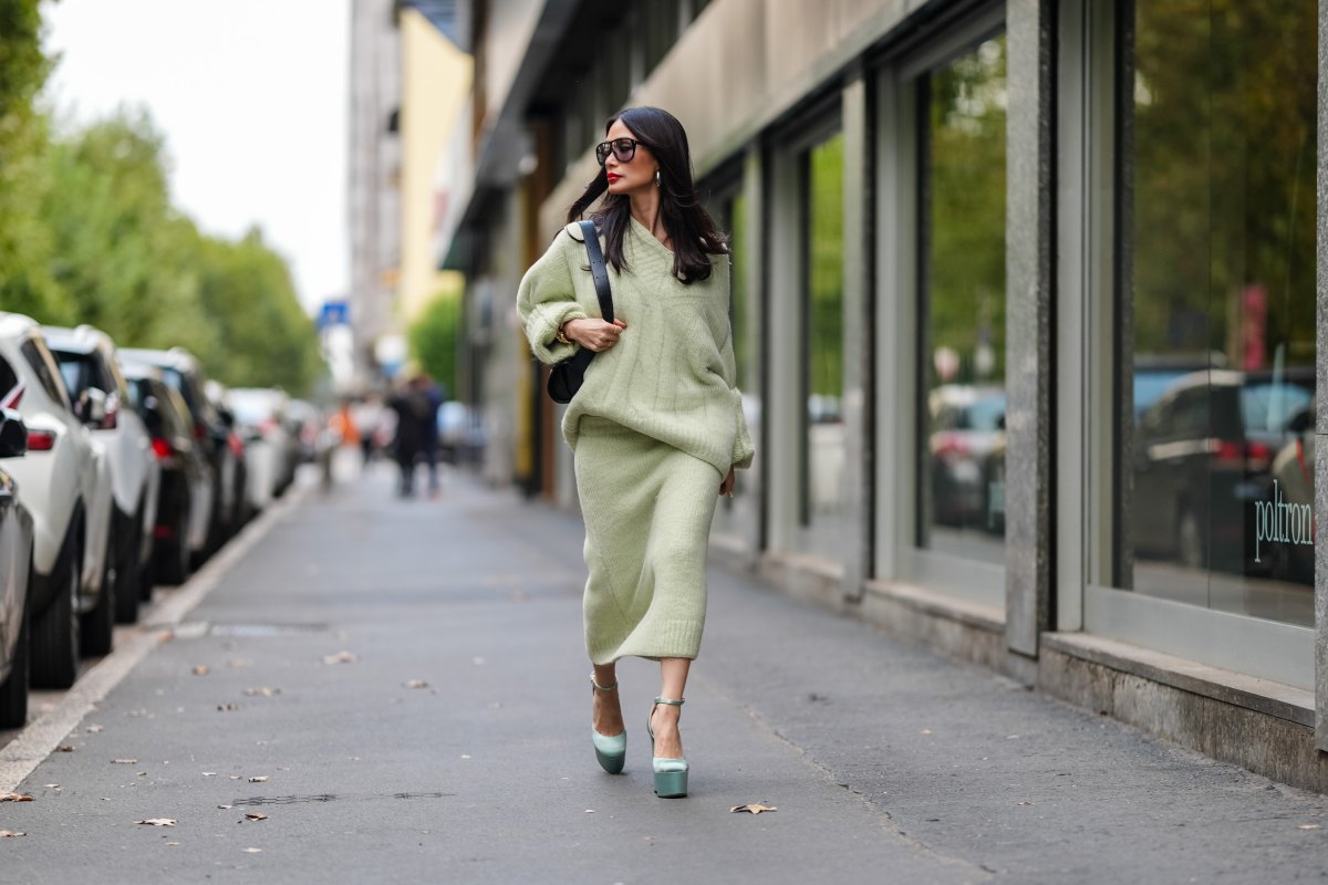 MILAN, ITALY - SEPTEMBER 18: Heart Evangelista wears silver earrings, light green oversized Jil Sander sweater, shiny black leather bag, black sunglasses, a white gold diamond ring, gold bracelets, light green Jil Sander sweater midi skirt, light blue satin platform heels with strap, outside Jil Sander, during the Milan Fashion Week Spring/Summer 2024-2025 on September 18, 2024 in Milan, Italy. (Photo by Edward Berthelot/Getty Images)