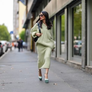 MILAN, ITALY - SEPTEMBER 18: Heart Evangelista wears silver earrings, light green oversized Jil Sander sweater, shiny black leather bag, black sunglasses, a white gold diamond ring, gold bracelets, light green Jil Sander sweater midi skirt, light blue satin platform heels with strap, outside Jil Sander, during the Milan Fashion Week Spring/Summer 2024-2025 on September 18, 2024 in Milan, Italy. (Photo by Edward Berthelot/Getty Images)