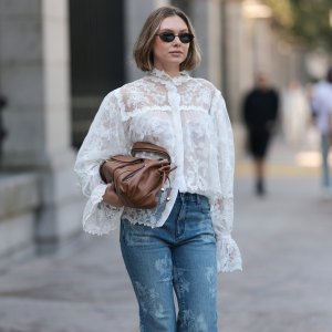 NEW YORK, NEW YORK - SEPTEMBER 14: Kate Smolianinova seen wearing Vehla Eyewear slim rectangular sunglasses in a dark brown. Her hair styled in a sleek chin-length bob with a soft middle part. A Kobi Halperin sheer white lace blouse with floral embroidery, high ruffled collar, voluminous sleeves and scalloped edges, paired with Kobi Halperin blue high-waist flared jeans featuring tonal floral jacquard detailing and a Gerard Darel soft brown leather handbag with gathered pleats and rounded handles, outside the Ulla Johnson show, during New York Fashion Week, on September 14, 2025 in New York City. (Photo by Jeremy Moeller/Getty Images)