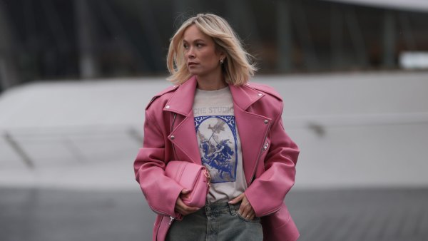MUNICH, GERMANY - MARCH 06: Nadine Berneis seen wearing The Frankie Shop pink oversized leather jacket, Acne Studios off-white / blue print pattern graphic cotton t-shirt, Acne Studios light blue / grey denim wide leg jeans / pans and Jacquemus pink leather Bambimou bag, on March 06, 2024 in Munich, Germany. (Photo by Jeremy Moeller/Getty Images)