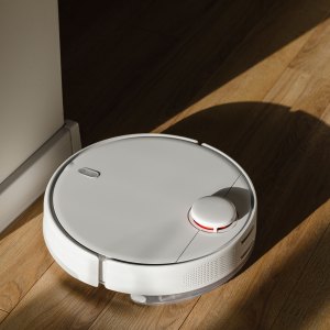 Robot vacuum cleaner on hardwood floor at home - stock photo