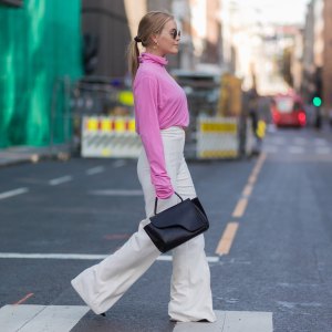 A guest wearing pink knit, white pants outside Line of Oslo on August 22, 2017 in Oslo, Norway.