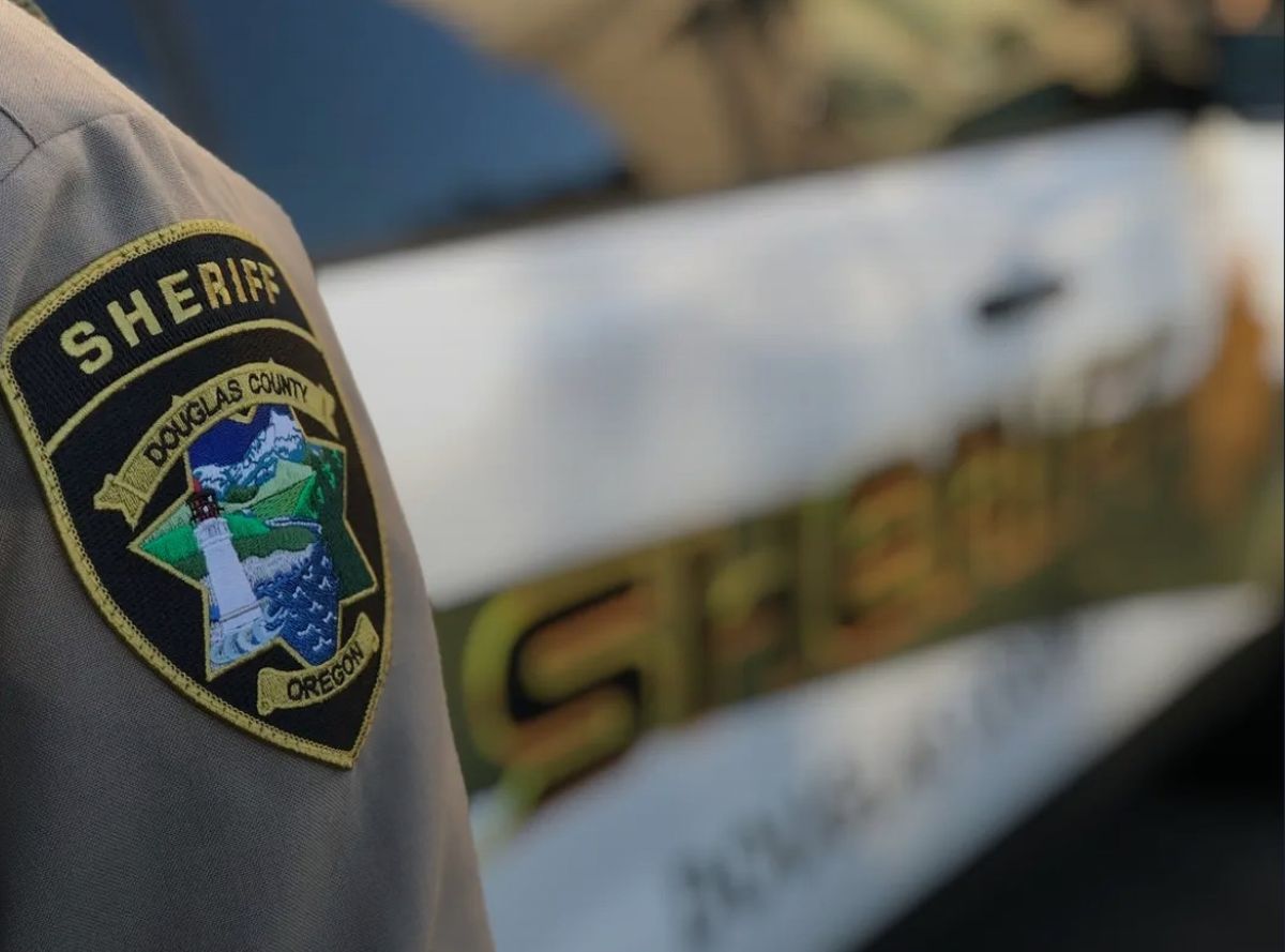 A Douglas County Sheriff's deputy stands near a patrol car