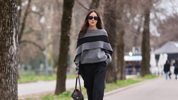 MILAN, ITALY - FEBRUARY 28: Tamara Kalinic wears brown long hair, black sunglasses, a gray knit poncho sweater with a large black stripe, black wide leg trousers, a black leather bag, black leather pumps shoes, outside Ferragamo, during Milan Fashion Week - Womenswear Fall/Winter 2026/2027, on February 28, 2026 in Milan, Italy (Photo by Edward Berthelot/Getty Images)