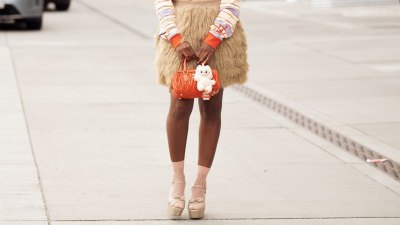 COPENHAGEN, DENMARK - AUGUST 07: Zufi Alexander wears beige mini skirt made of fur, orange MiuMiu bag with beige Labubu charm, purple, yellow and orange stripped long sleeve top, light pink socks, beige platform shoes during Copenhagen Fashion Week day four on August 07, 2025 in Copenhagen, Denmark. (Photo by Raimonda Kulikauskiene/Getty Images)