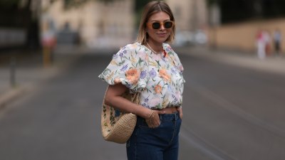 Aline Kaplan wearing Baum & Pferdgarten wide leg blue denim pants, & other stories white flower pattern cropped blouse and orange summer heels and Mango orange black shades on June 06, 2023 in Berlin, Germany.