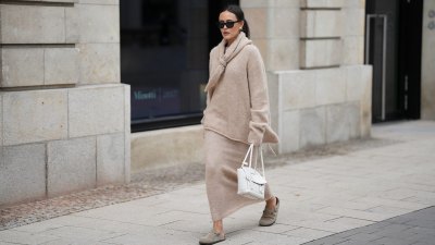 HAMBURG, GERMANY - OCTOBER 16: Laura Noltemeyer is seen wearing an oversized beige alpaca wool sweater with tie-back detailing by Aylin König; a long alpaca wool knit skirt in a straight cut by Aylin König; an alpaca knit scarf draped and knotted around the neck by Aylin König; beige suede Boston clogs by Birkenstock; a white intrecciato leather handbag called „Arco Bag“ by Bottega Veneta; slim black cat-eye sunglasses by Yves Saint Laurent; gold statement earrings with a green stone detail by Mango; her brown and straight hair is tied in a low ponytail on October 16, 2025 in Hamburg, Germany. (Photo by Moritz Scholz/Getty Images)