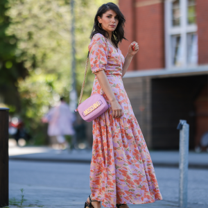Anna Wolfers wearing colorful wrap dress via Goldig Shop, pink Moschino leather bag and brown heeled clogs on May 31, 2021 in Hamburg, Germany.
