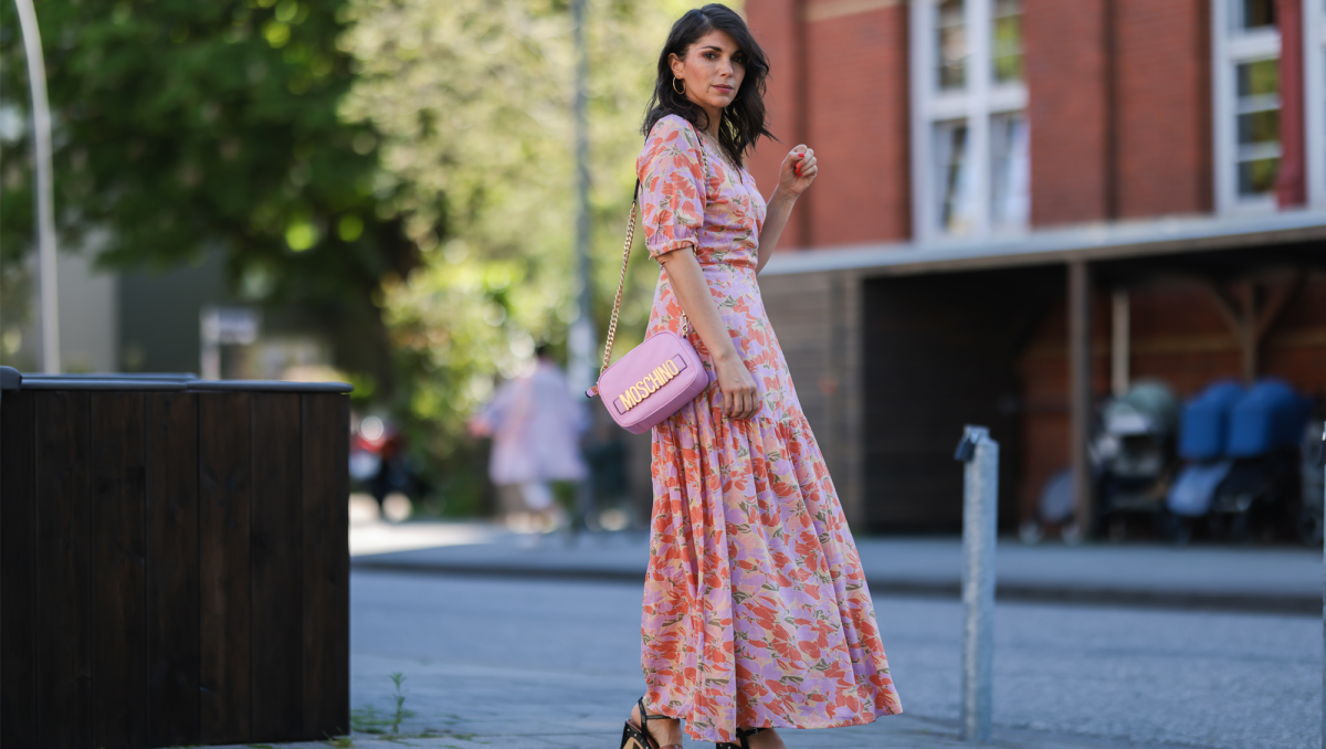 Anna Wolfers wearing colorful wrap dress via Goldig Shop, pink Moschino leather bag and brown heeled clogs on May 31, 2021 in Hamburg, Germany.