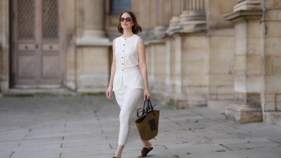 PARIS, FRANCE - MAY 25: Marissa Cox wears a white Arket linen skirt set, a sleeveless long top with buttons, a brown raffia Loewe basket bag, ATP Atelier brown suede sandals / shoes, Jimmy Fairly x Reformation sunglasses, during a street style fashion photo session, on May 25, 2024 in Paris, France. (Photo by Edward Berthelot/Getty Images)