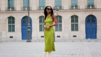 PARIS, FRANCE - APRIL 29: Emilie Joseph wears black large sunglasses, micro crystal earrings, a green satin / silk asymmetric one strap shoulder midi tube dress, gold bracelets, pale yellow shiny leather block heels knees boots / high boots , during a street style fashion photo session, on April 29, 2023 in Paris, France. (Photo by Edward Berthelot/Getty Images)