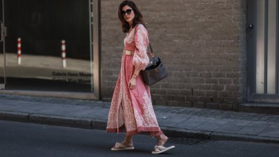 DUSSELDORF, GERMANY - JULY 24: Ira Meindl is seen wearing a rose, pink and white printed long Zimmermann dress with a beige belt, a black leather handbag from Hermes, black Saint Laurent sunglasses and beige Catwalk slipper on July 24, 2022 in Dusseldorf, Germany. (Photo by Jeremy Moeller/Getty Images)