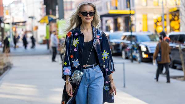NEW YORK, NEW YORK - FEBRUARY 10: Victoria Magrath wears cuffed denim jeans, silver bag, jacket with floral print, heels outside Kate Spade during New York Fashion Week on February 10, 2023 in New York City. (Photo by Christian Vierig/Getty Images)