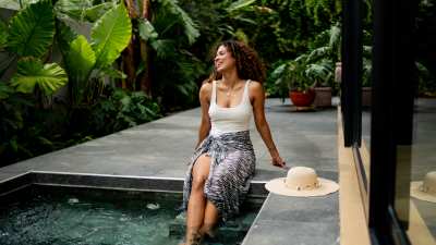 Young woman on swimming pool at house back yard