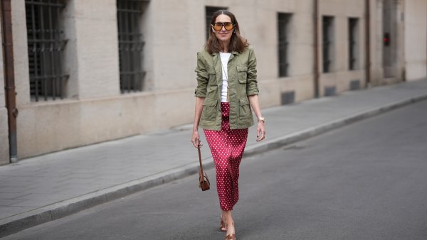 MUNICH, GERMANY - APRIL 28: Annette Weber is seen wearing an olive green cotton field jacket with a relaxed fit, button front closure and multiple flap patch pockets from AG Jeans; a white cotton crew neck top with a fitted silhouette from Brunello Cucinelli; a red satin longuette skirt with a straight silhouette and white polka dot print from Glamometer x Seidensticker; brown calfskin "Oasis” sandals with an open toe, low block heel and cut out strap detail from Hermès; a natural pedicure visible; a structured Celine Tabou shoulder bag, characterized by a flap design with a distinctive golden padlock "Celine Paris" that recalls the Celine 16 line, made of calfskin; a long gold chain necklace with a tassel pendant from Manuela Fumagalli; multiple gold rings; dark nail polish; oversized aviator acetate sunglasses with orange tinted lenses from Bottega Veneta; a Rolex Day-Date 36 Everose rose gold with Oyster bracelet; her medium brown hair is worn loose in soft waves with a center part; with natural make up on April 28, 2026 in Munich, Germany. (Photo by Moritz Scholz/Getty Images)