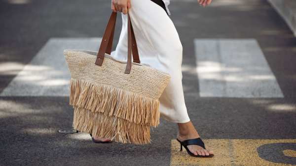 CANNES, FRANCE - MAY 21: Gili Biegun wears long white and cream silk maxi dress with multiple small buttons, black-and-white silk scarf tied around the waist, oversized raffia beach bag with fringe and brown leather straps, black flip-flop kitten heels from AGL during the 79th annual Cannes Film Festival on May 21, 2026 in Cannes, France. (Photo by Raimonda Kulikauskiene/Getty Images)