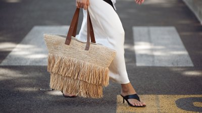 CANNES, FRANCE - MAY 21: Gili Biegun wears long white and cream silk maxi dress with multiple small buttons, black-and-white silk scarf tied around the waist, oversized raffia beach bag with fringe and brown leather straps, black flip-flop kitten heels from AGL during the 79th annual Cannes Film Festival on May 21, 2026 in Cannes, France. (Photo by Raimonda Kulikauskiene/Getty Images)