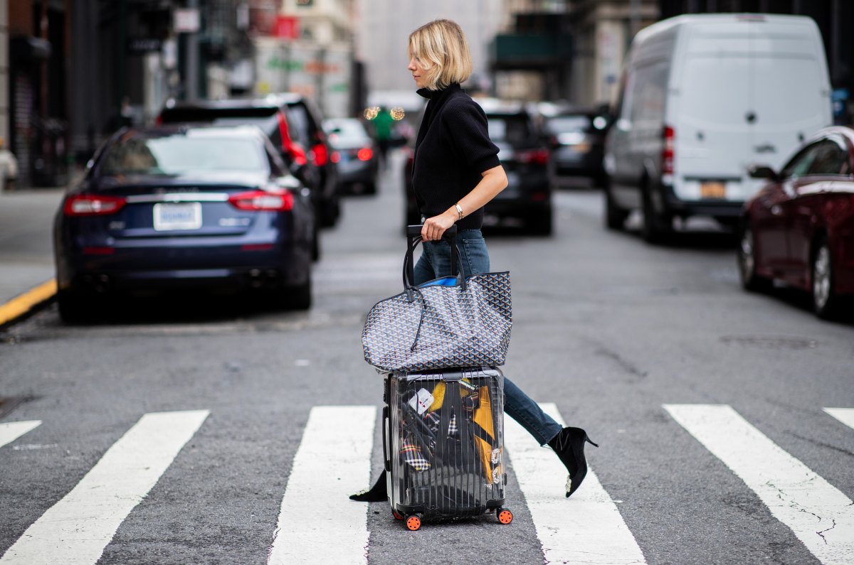 NEW YORK, NY - SEPTEMBER 12: Lisa Hahnbueck wearing velvet Roger Vivier boots, Re/done Levis jeans, Self Portrait turtleneck, Goya bag, Rimowa x Off White travel bag, trolley, suitcase is seen during New York Fashion Week Spring/Summer 2019 on September 12, 2018 in New York City. (Photo by Christian Vierig/Getty Images)