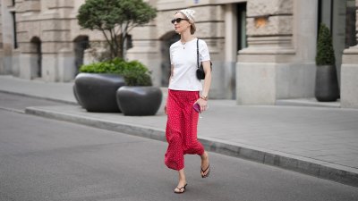 MUNICH, GERMANY - APRIL 29: Marlies Pia Pfeifhofer is seen wearing a white crew neck t-shirt from Sézane; a red polka dot "Raus Sally" silk midi skirt from Sézane; black kitten heeled thong sandals from H&M; black nail polish pedicure; a small structured black leather "Osmo" shoulder bag with contrasting tonal seams from Poléne; a multicolored beaded necklace from Ondo Roma; an iPhone and wired headphones from Apple; a "Lady Datejust" bicolor wristwatch from Rolex; a healing stones bracelet from Pilgrim; a gold medallion pendant necklace from Marlow Laz; a multicolored beaded necklace from Ondo Roma; "Blum" sunglasses with small black acetate frames from Kaleos; her blonde hair is worn in a bob with a handmade cream crochet bandana; with a natural make-up on April 29, 2026 in Munich, Germany. (Photo by Moritz Scholz/Getty Images)