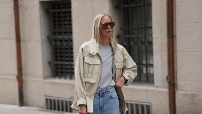 MUNICH, GERMANY - APRIL 29: Mirja Klein is seen wearing an off-white "Hope" leather jacket with a high funnel collar, zip front closure, large chest patch pockets and a peplum hem from Ducie London; a gray crew neck t-shirt from COS; light blue wide-leg denim jeans from Rohe; off-white leather kitten heel pumps from Massimo Dutti; a dark olive perforated suede "Midi Stockholm" top handle bag with gold tone hardware from DeMellier; a nude nail polish manicure; oversized "Scudo Shield" sunglasses with brown tinted lenses from Bottega Veneta; her blonde straight hair is worn loose; with a natural make-up on April 29, 2026 in Munich, Germany. (Photo by Moritz Scholz/Getty Images)
