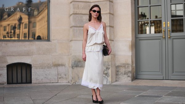 PARIS, FRANCE - MARCH 08: Sophia Roe wears black sunglasses, gold with rhinestones necklace, a white satin lace trim slip / V-neck / belted top, a white satin / silk with embroidered lace borders pattern midi skirt, a black quilted leather handbag, black shiny patent leather pointed pumps heels shoes, outside Magda Butrym, during Paris Fashion Week - Womenswear Fall/Winter 2026/2027, on March 08, 2026 in Paris, France (Photo by Edward Berthelot/Getty Images)