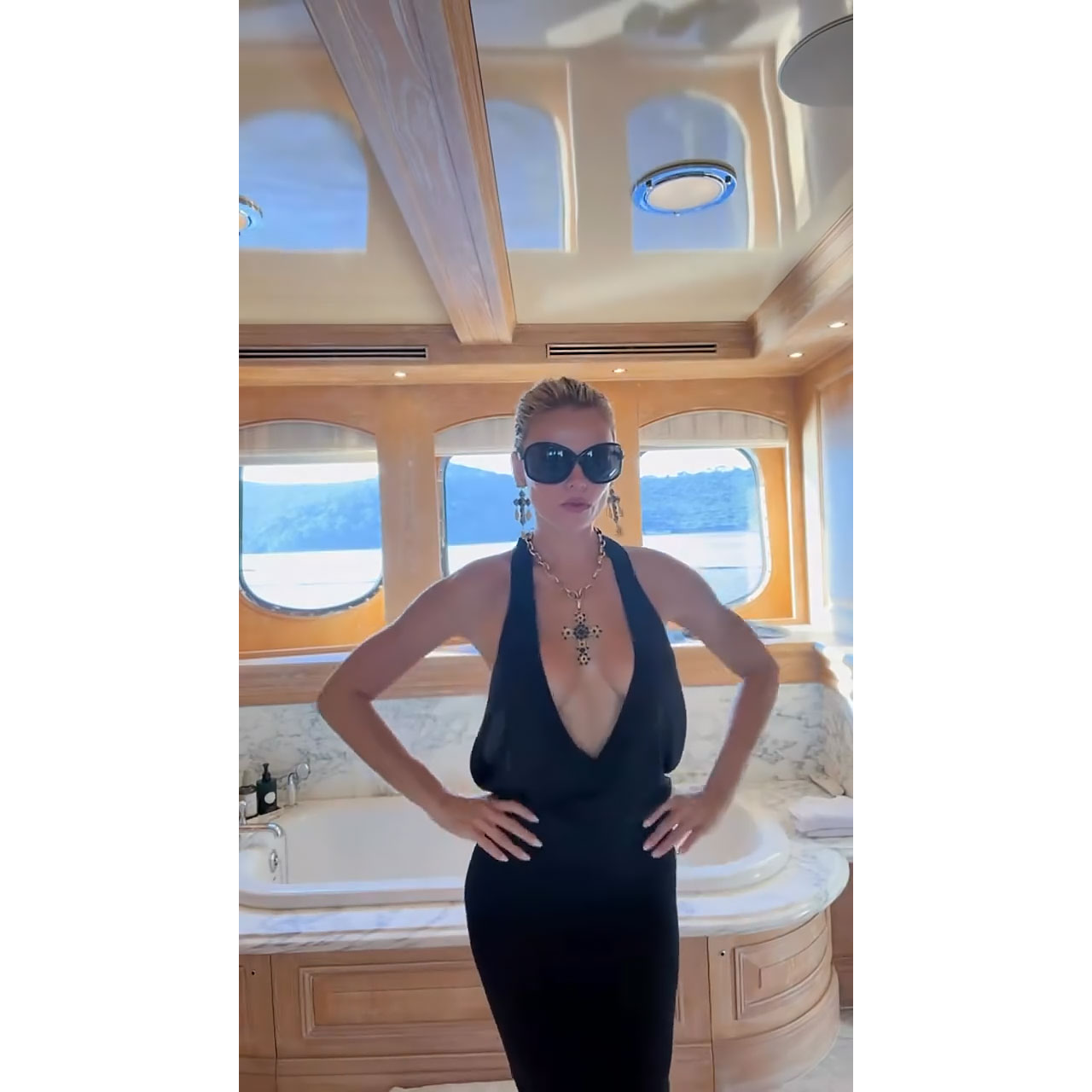 Brooks Nader Narrowly Avoids Wardrobe Malfunction While Going Braless in Plunging Dress on a Yacht
