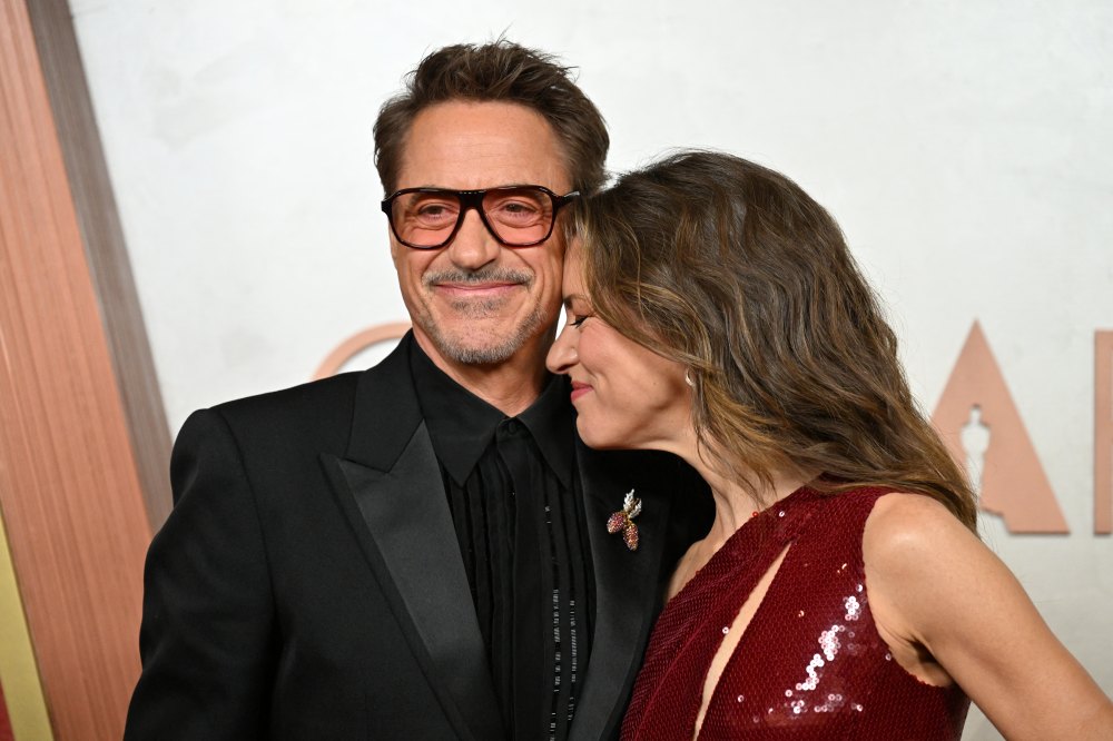Susan Downey nuzzling Robert Downey Jr.'s neck on a red carpet.