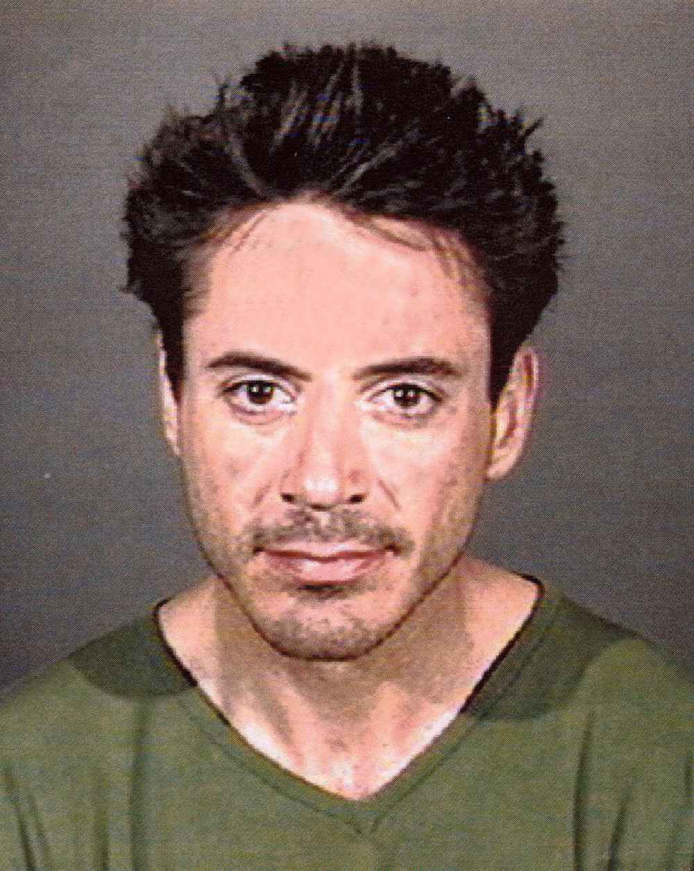 Robert Downey Jr. posing for a mugshot.