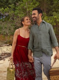 Jennifer Lopez and Brett Goldstein smiling together on a beach in "Office Romance."
