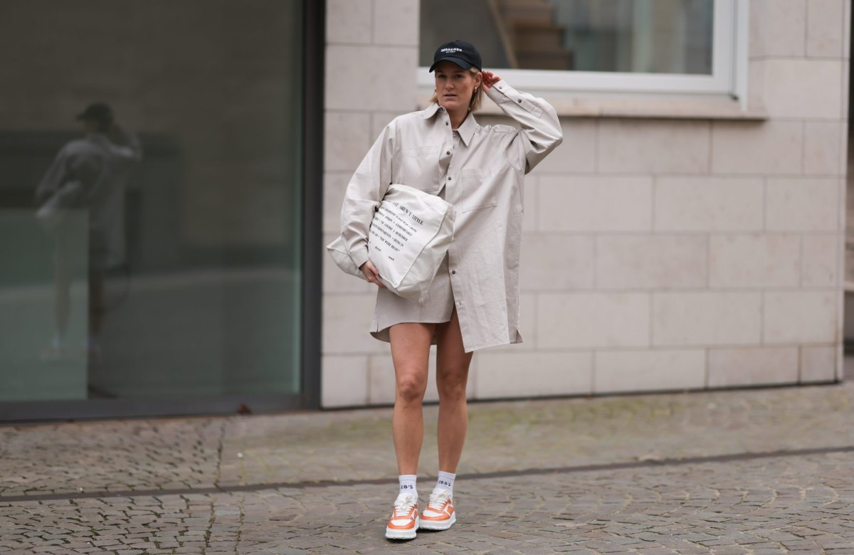 COLOGNE, GERMANY - MARCH 20: Victoria Thomas seen wearing Hernameis black logo cap, By Aylin Koenig beige oversized shirt, Hernameis beige printed shopper bag, The Wants x Copenhagen Studios orange and white sneaker on March 20, 2023 in Cologne, Germany. (Photo by Jeremy Moeller/Getty Images)