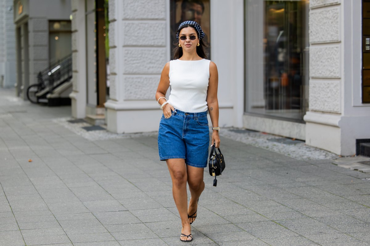 BERLIN, GERMANY - AUGUST 03: Bella Emar wears blue Polo Club Jeans Shorts & white Top, H&M sandals, Miu Miu Sunglasses & black Miu Miu bag, blue head scarf on August 03, 2025 in Berlin, Germany. (Photo by Christian Vierig/Getty Images)