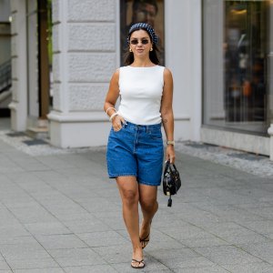 BERLIN, GERMANY - AUGUST 03: Bella Emar wears blue Polo Club Jeans Shorts & white Top, H&M sandals, Miu Miu Sunglasses & black Miu Miu bag, blue head scarf on August 03, 2025 in Berlin, Germany. (Photo by Christian Vierig/Getty Images)