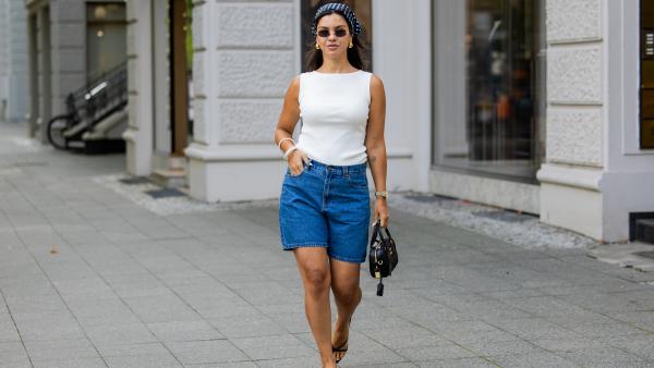 BERLIN, GERMANY - AUGUST 03: Bella Emar wears blue Polo Club Jeans Shorts & white Top, H&M sandals, Miu Miu Sunglasses & black Miu Miu bag, blue head scarf on August 03, 2025 in Berlin, Germany. (Photo by Christian Vierig/Getty Images)
