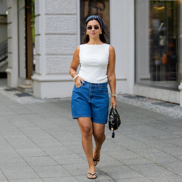 BERLIN, GERMANY - AUGUST 03: Bella Emar wears blue Polo Club Jeans Shorts & white Top, H&M sandals, Miu Miu Sunglasses & black Miu Miu bag, blue head scarf on August 03, 2025 in Berlin, Germany. (Photo by Christian Vierig/Getty Images)