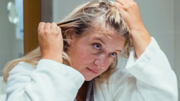 Blond woman applies oil to her hair with massage. Beauty caring for scalp and hair.