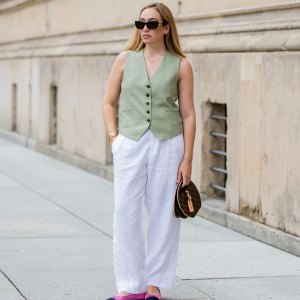BERLIN, GERMANY - JULY 01: Sonia Lyson wears pink black Chanel ballerinas, white linen pants & green vest Zara, Louis Vuitton bag, sunglasses Miu Miu during the Berlin Fashion Week Spring/Summer 2025 on July 01, 2024 in Berlin, Germany. (Photo by Christian Vierig/Getty Images)